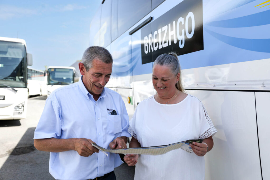 Personnel Maury Transports préparant un voyage en groupe devant un autocar