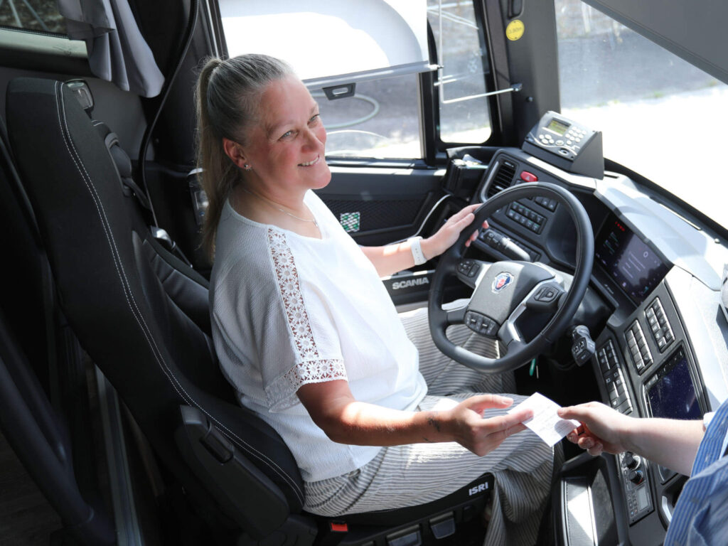 Conductrice Maury Transports accueillant des voyageurs à bord d'un autocar